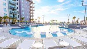 a swimming pool at a resort with chairs and slides at Holiday Inn Club Vacations Myrtle Beach Oceanfront in Myrtle Beach