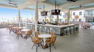 a restaurant with tables and chairs and a bar at Holiday Inn Club Vacations Myrtle Beach Oceanfront in Myrtle Beach
