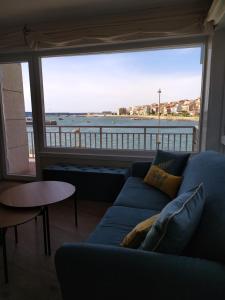 a living room with a blue couch and a large window at Vacacional muelle alto A Guarda in A Guarda