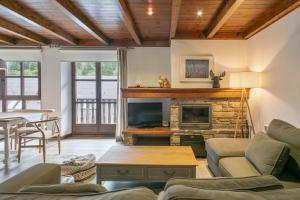 a living room with a couch and a fireplace at Luderna - Apartamento Val de Ruda B1 Morèdo in Baqueira-Beret