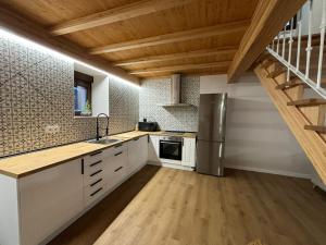 cocina con armarios blancos y techo de madera en Cabanas do Carpinteiro / Santiago de Compostela - Rías Baixas, en Pontevedra