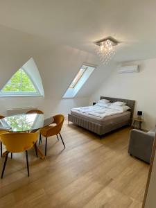 ハイドゥソボスローにあるHéli apartmanのベッドルーム1室(ベッド1台、テーブル、椅子付)