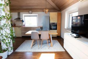 a kitchen with a wooden table and chairs in a room at Bivalvia Apartments in Koper