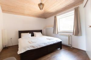 a bedroom with a bed with white sheets and a window at Bivalvia Apartments in Koper