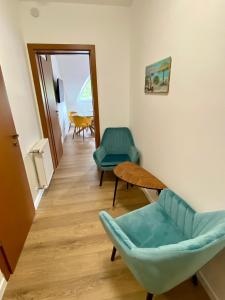 a living room with two chairs and a table at Héli apartman in Hajdúszoboszló