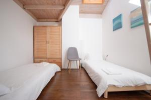 um quarto com duas camas e uma cadeira. em Bivalvia Apartments em Koper