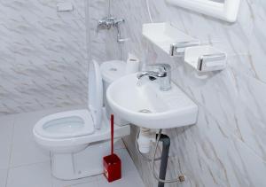 a white bathroom with a toilet and a sink at Voie lactée in Dakar