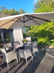 a table and chairs under an umbrella on a patio at Aufatmen in Ahlbeck in Ahlbeck +19 photos