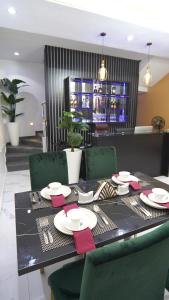 a black table with green chairs and a dining room at SHORTLETMART Apartments in Lekki