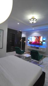 a bedroom with a bed and a flat screen tv at SHORTLETMART Apartments in Lekki