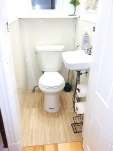 een badkamer met een wit toilet en een wastafel bij 3 bedrooms 2 stops to Manhattan in Long Island City
