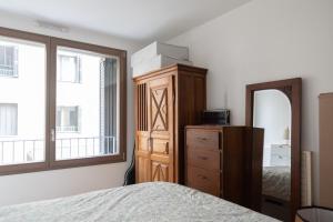 um quarto com uma cama, uma cómoda e um espelho em Cozy 55 m with terrace in Paris em Paris