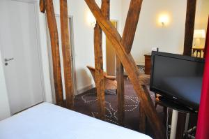 a bedroom with a bed and a flat screen tv at Hôtel de France in Auch