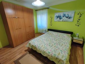 a bedroom with a bed and a wooden closet at Apartman Jadranka in Veli Lošinj