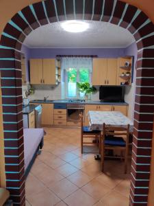 an archway in a kitchen with a table at Apartman Jadranka in Veli Lošinj