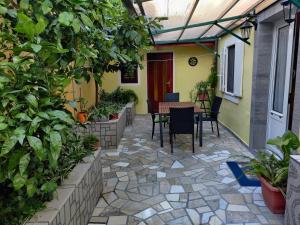 un patio con mesa, sillas y plantas en Apartman Jadranka, en Veli Lošinj