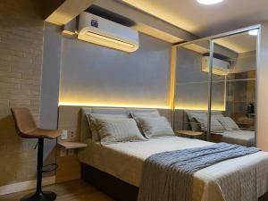 um quarto com uma cama grande e um espelho em Flat de Luxo em Pinheiros Faria Lima em São Paulo