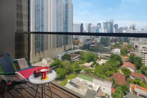 un balcón con mesa y sillas en una ciudad en Hotel Indigo Bangkok Wireless Road, an IHG Hotel, en Bangkok