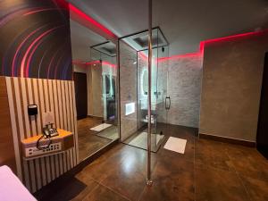 ピンダモニャンガバにあるMotel Prestige Pindaのバスルーム(ガラス張りのシャワー、シンク付)