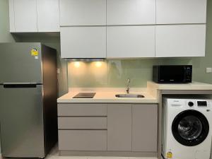 a kitchen with white cabinets and a washing machine at City View Studio Unit in Phnom Penh