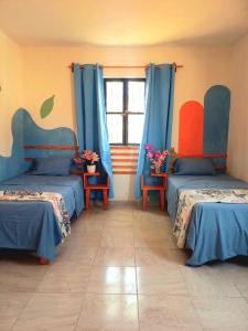Cette chambre comprend 2 lits et une fenêtre. dans l'établissement Casa Aeropuerto Mérida, Yucatán, à Mérida