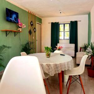 d'un salon et d'une salle à manger avec une table et des chaises. dans l'établissement Casa Aeropuerto Mérida, Yucatán, à Mérida