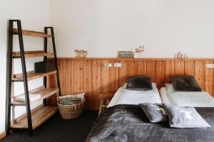 two beds in a room with wooden walls at de Pol in Haaksbergen