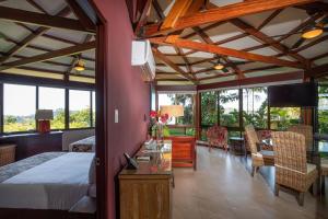 a bedroom with a bed and a table and chairs at Tulemar Resort in Manuel Antonio +157 photos