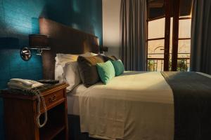 Un dormitorio con una cama y un teléfono en una mesa. en Miravida Soho Hotel & Wine Bar en Buenos Aires