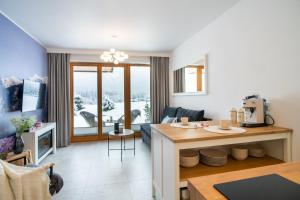 uma cozinha e uma sala de estar com uma mesa em Apartamenty Enklawa pod Giewontem by Apart Concept Podhale em Kościelisko