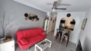 uma sala de estar com um sofá vermelho e uma cozinha em AYAHAY, Modern luxury apartment just 50 m from Playa Del Puerto em Puerto de Mazarrón