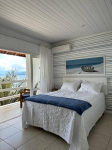 a bedroom with a bed and a large window at Casa de veraneio com deck em Passa Terra, Ilha Grande in Angra dos Reis
