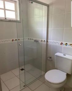 La salle de bains est pourvue de toilettes et d'une douche en verre. dans l'établissement Casa de Campo - Chácara, à Curitiba