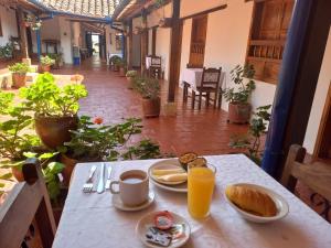 a table with two plates of food and orange juice at Hotel Casa del Marquez de Bahichala in Barichara