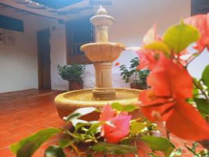 une fontaine au milieu d'une pièce fleurie dans l'établissement Hotel Casa del Marquez de Bahichala, à Barichara