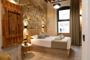 1 dormitorio con cama y pared de ladrillo en HGB CATHEDRAL en Alicante