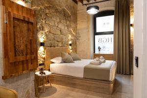 1 dormitorio con cama y pared de ladrillo en HGB CATHEDRAL, en Alicante