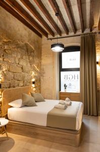 sypialnia z łóżkiem i ceglaną ścianą w obiekcie HGB CATHEDRAL w Alicante