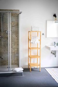 a bathroom with a wooden shelf next to a sink at Das Quartier in Klagenfurt