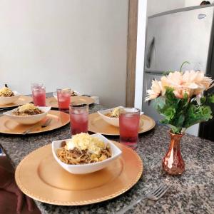 una mesa con platos y tazones de comida. en Encantador apartamento en pozos colorados, en Santa Marta