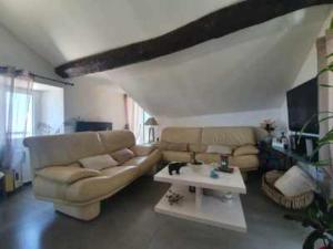 a living room with a couch and a table at Petit duplex atypique in Furiani