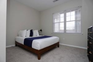 a white bedroom with a bed and a window at Comfortable Apartment with Pool Gym & other Amenities #2306 in Woburn