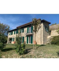 a large brick house with green shutters at Villa Greta in Ponti