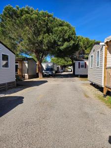 Eine Straße mit zwei Häusern, einem Baum und einem Truck in der Unterkunft Casa Luisa Mobil Home in Canet-en-Roussillon