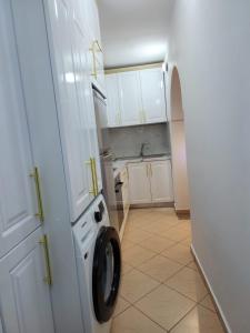 a kitchen with a washing machine in a doorway at Angels Apartment in Berat