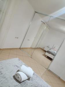 a white room with a bed and a mirror at Angels Apartment in Berat