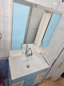 a bathroom with a sink and a mirror at Angels Apartment in Berat