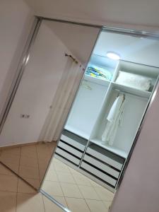 uma porta de vidro num quarto com um frigorífico em Angels Apartment em Berat