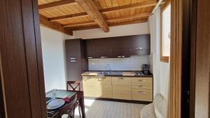 a kitchen with wooden cabinets and a table in a room at Cala Dei Mori in Livorno