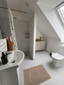 a bathroom with a white sink and a toilet at Nordgården - ferie på landet in Skibby
